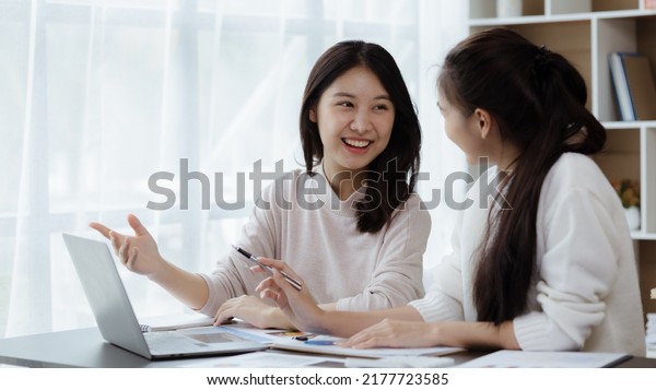Two\
beautiful Asian women are meeting together in a company meeting\
room, meeting to discuss plans to develop the business to grow and\
follow the business plan. Business meeting\
idea.