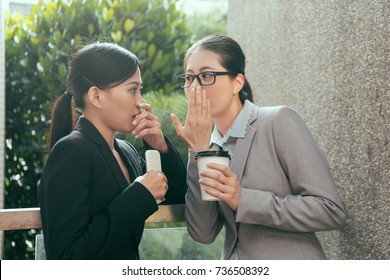 Two Beautiful Asian Women Talking About Office Gossip At Break Time Outside Of The Studio.
