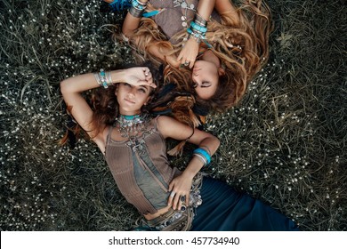 Two beautiful boho girls in ethnic jewelry outdoors. Top view