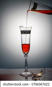 Two Beautiful Broken Glasses With Red Wine Inside On A White Background. Two Glass Broken Glasses On The Skylight.