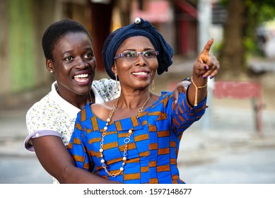 two beautiful business women pointing their finger forward to show something smiling.