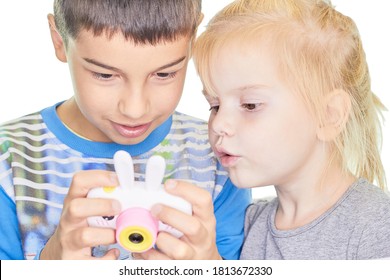 Zwei schöne Kinder mit einer Kamera ein kleiner Junge und ein Mädchen, das ein Gadget spielt. Konzept der Ausbildungstechnologie.
