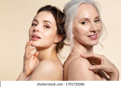Zwei wunderschöne Frauen unterschiedlichen Alters mit perfektem Skin-Headshot-Portrait. Senior Lady und junges Mädchen in Unterwäsche, die sich für die Kamera von hinten positionieren. Schönheitssalon-Verfahren und häusliche Pflege