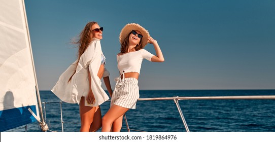 Two beautiful female friends on luxury yacht. Having fun together and enjoying the sun while sailing in the sea. Traveling and yachting concept. - Powered by Shutterstock