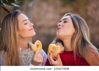 Two Beautiful Friends Eating Donuts 