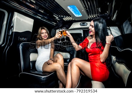 Two beautiful girls celebrating birthday party in a limousine