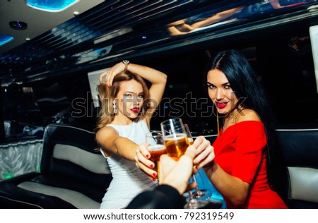 Two beautiful girls celebrating birthday party in a limousine