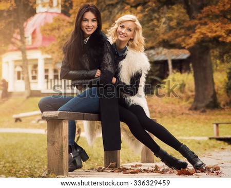 Two beautiful girls friends in autumn park 