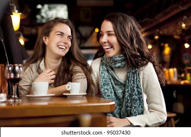 Two Beautiful Girls Laughing In A Cafe Bar