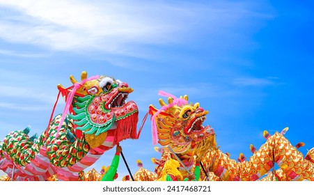 Two Beautiful Golden and Red Chinese Dragon Dance Performance Parade against Blue Sky background during Chinese New Year Celebration Festival at Thailand - Powered by Shutterstock