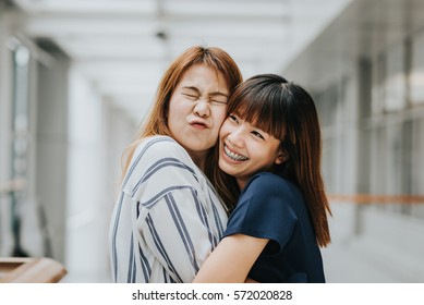 Two Beautiful Happy Asian Girls Friends Laughing And Hug. Friendship Concept.