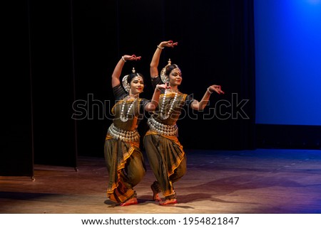 Two Beautiful Indian classical odissi dancers performing at stage.