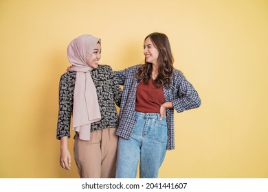 Two Beautiful Muslim Women Laughing While Chatting And Embracing With Hands On Shoulders With Copyspace