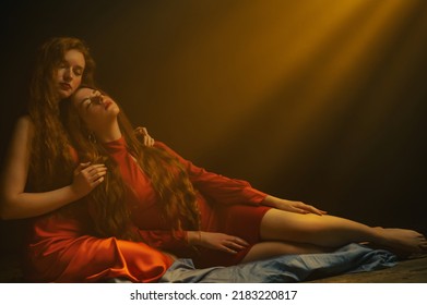  Two Beautiful Redhead Freckled Women Wearing Red Dresses Posing In Smoke, Darkness And Warm Light. Studio Art Portrait. Copy, Empty Space For Text