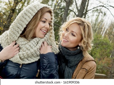 Two beautiful smiling young woman in autumn outdoors.
