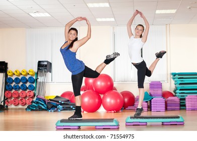 Two Beautiful Sport Woman Doing Stretching Fitness Exercise At Sport Gym. Step.