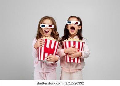 two beautiful surprised caucasian little girls in red-blue 3d glasses holding popcorn buckets and watching movie - Powered by Shutterstock