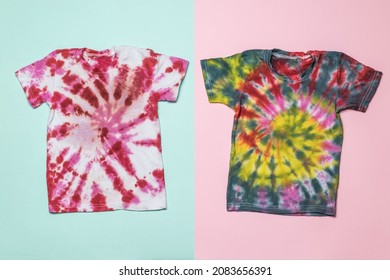 Two Beautiful Tie Dye T-shirts On A Two-tone Background. Coloring Clothes By Hand At Home. Flat Lay.