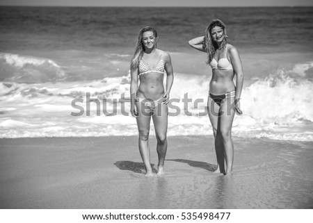 Two Beautiful Woman on the beach in swimming suits bikini