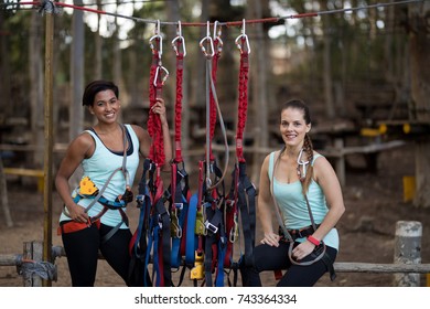 Two beautiful woman standing near hanging harness in adventure park - Powered by Shutterstock