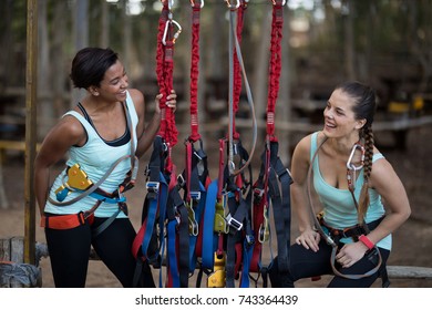 Two beautiful woman standing near hanging harness in adventure park - Powered by Shutterstock