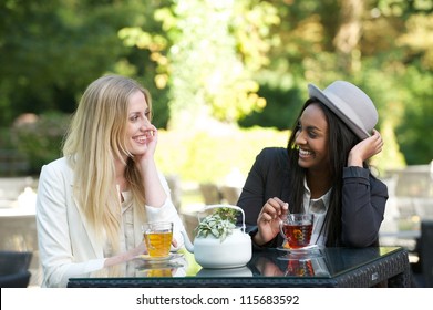 Two Beautiful Women Drinking Tea Outdoors