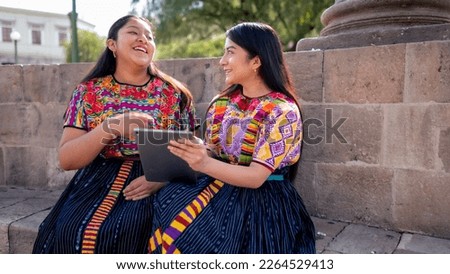 Two beautiful women enjoy a conversation in a local park.