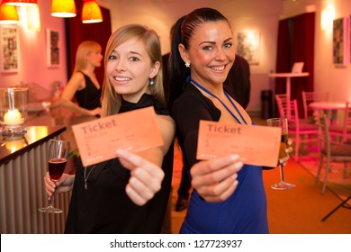 Two Beautiful Women Presenting Tickets For A Theater, Cinema Or A Concert