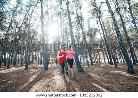 two beautiful women running through the forest