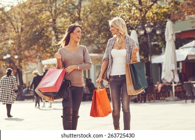 Two Beautiful Women Walking Down The Street After Shopping