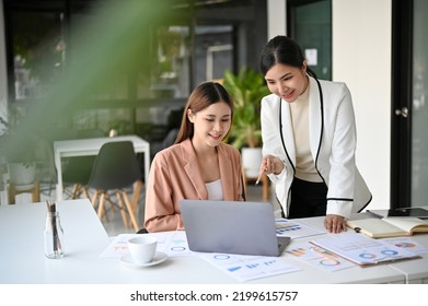 Two Beautiful Young Asian Businesswomen Working Together In The Office. Professional Asian Female Boss Training And Coaching Her Assistant.