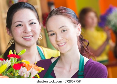 Two Beautiful Young Female Employees In A Busy Flower Shop