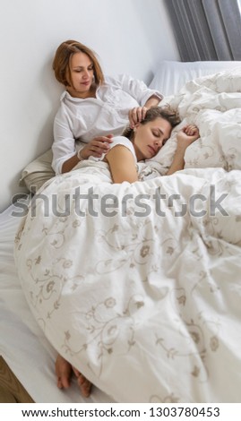 Similar – Mother reading book to her sons in the bed