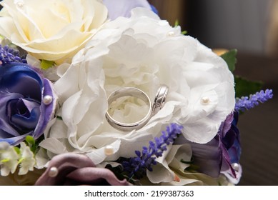 Two Beautifull Wedding Bands Sat Inside A Handmade Flower That Is One Of Many In The Brides Wedding Bouquet