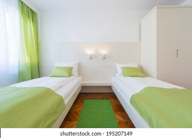 Two Beds Bedroom With Bedside Table And Lamp.