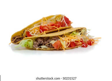 Two Beef Tacos On Corn Torillas With Beef, Lettuce, Tomatoes And Cheese On A White Background With Copy Space