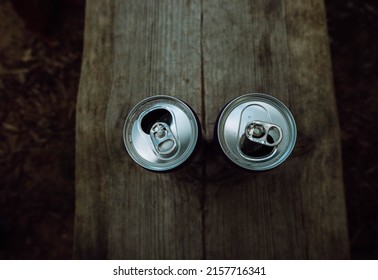 Two Beer Cans Side By Side. On A Wooden Board