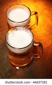 Two Beer Mugs Close-up On Wooden Table