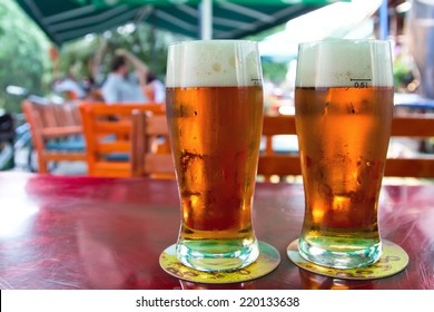 Two Beers On Table In The Garden Pub.