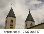 The two bell towers of the Church of St. James the Apostle in Medjugorje during a cloudy day in Bosnia Herzegovina.