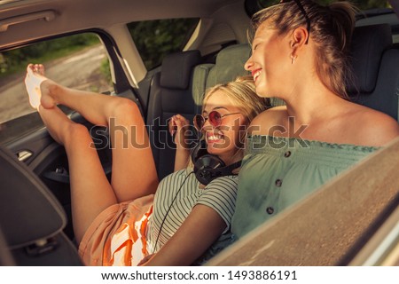 Similar – Two young women resting sitting inside of car