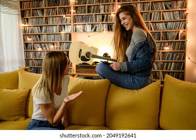 Two Best Friends Hanging Out At Home Together And Having Fun While Sitting On The Couch At Home