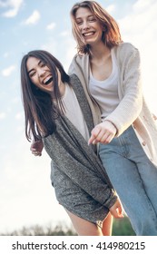 Two Best Friends Hugging And Laugh Under Blue Sky