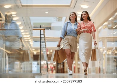 Two best friends linking each other arms shopping in popular mall