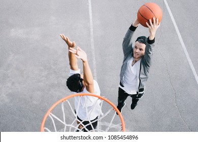 Two Best Friends Are Playing Basketball Near The Basket. One Of Them Is Trying To Defence His Territory With The Basket On There While Another One Is Going To Throw The Ball Into The Basket