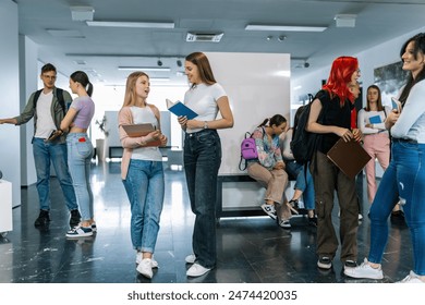 Two best friends, students, walk in the hall of school surrounded with their friends. They talk about the book. - Powered by Shutterstock