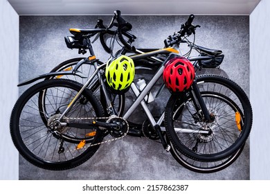 Two bicycles hang on a hanging structure on the wall in the apartment. Bicycle storage solution at home. Sports and safety. Sports equipment, eco-friendly transport, save nature - Shutterstock ID 2157862387