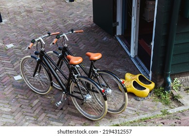 Two bicycles next to two typical wooden Dutch shoes. Concept of typical Dutch footwear. Sustainable urban mobility. Way of life in the Netherlands. - Shutterstock ID 2194312557