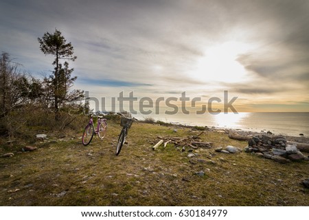 Two bicycles standing at the grass at the beach. Ocean view from the pebble shore in the island of Jomfruland, Norway.