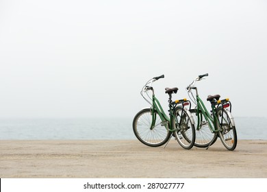 Two Bicycles Waiting By The Sea.